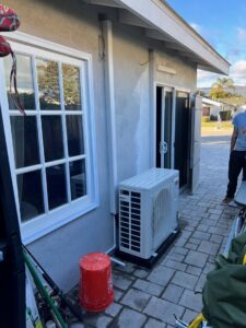 An outdoor mini-split air conditioning unit installed next to a residential building by MB Heating and Air in Northridge, CA.