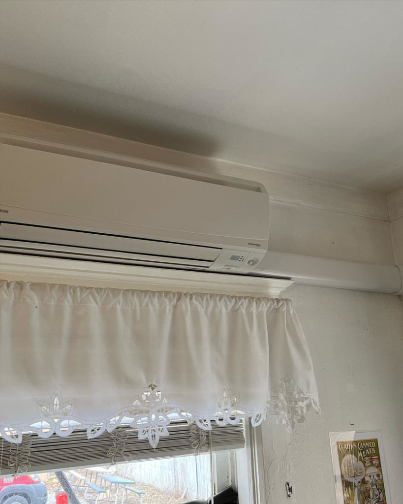 An indoor mini-split air conditioning unit professionally installed above a window by Voegeli Heating & A/C, Inc. in Toledo, OH.