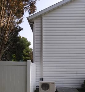A newly installed outdoor mini-split air conditioning unit on the side of a house by Your HVAC Guy in Aurora, IL.