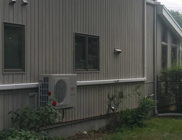 A mini-split air conditioning unit installed on the side of a house by Accurate Conditioning in Sayreville, NJ.