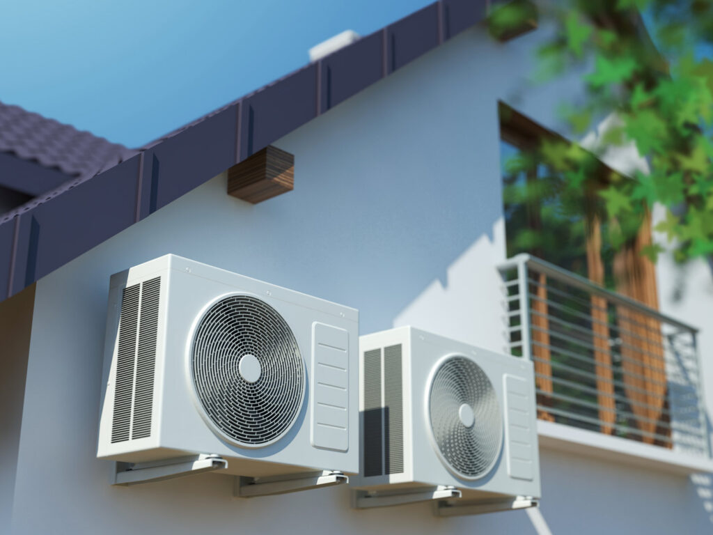 Two outdoor mini-split air conditioning units installed on the side of a house by Reed's Heating & Cooling in Toms River, NJ.