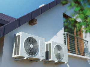 Two outdoor mini-split air conditioning units installed on the side of a house by Reed's Heating & Cooling in Toms River, NJ.