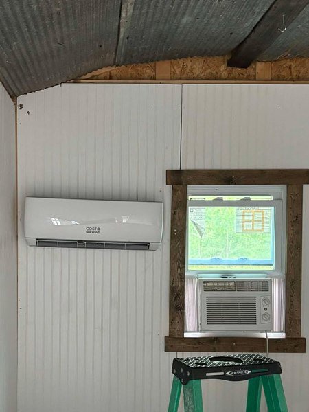 A newly installed mini-split indoor unit and a window air conditioner by Merriam Elite Solutions in Satsuma, AL.
