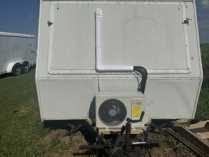 A mini-split condenser unit installed on the back of a white trailer by HD Precision Works in Iota, LA.