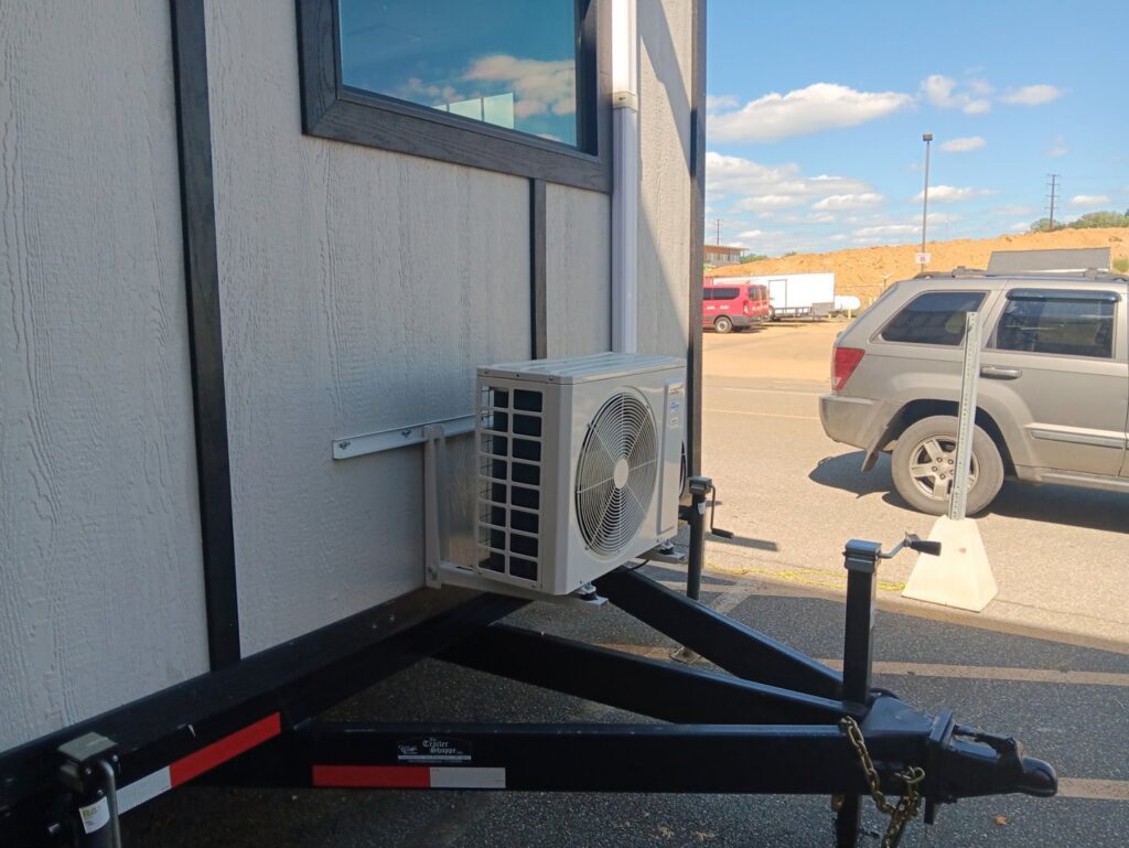 An outdoor mini-split condenser unit installed on a trailer, indicating mobile or specialized HVAC service by JJJ Techs Heating and Cooling in Kinzers, PA.