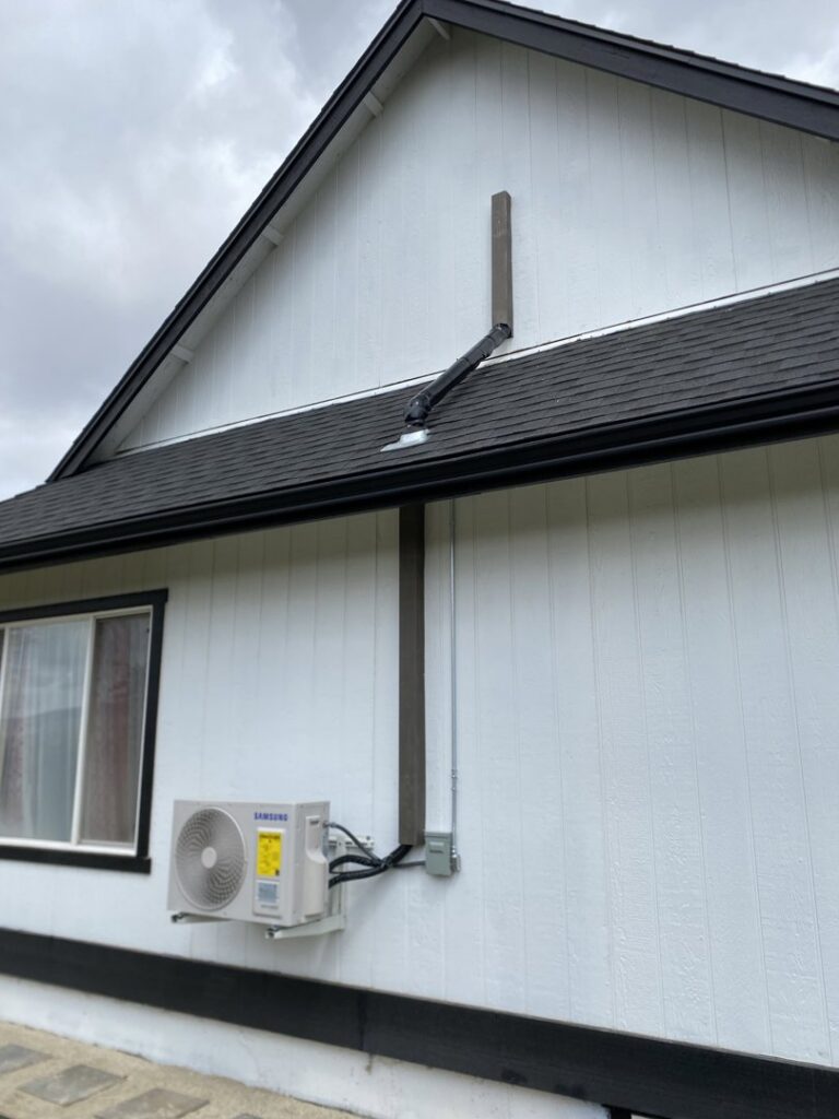 A newly installed outdoor mini-split heat pump unit on the side of a home by Desert Air, LLC in Sun Valley, NV.