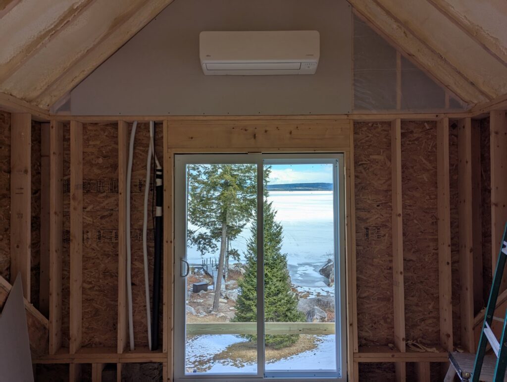 An indoor mini-split heat pump head unit installed in a room under construction by Kinney Family Heat Pumps in Augusta, ME.