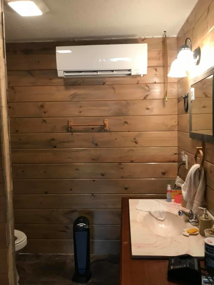 A mini-split HVAC indoor unit installed on a wooden wall in a bathroom by R & R H.V.A.C in Knoxville, TN.