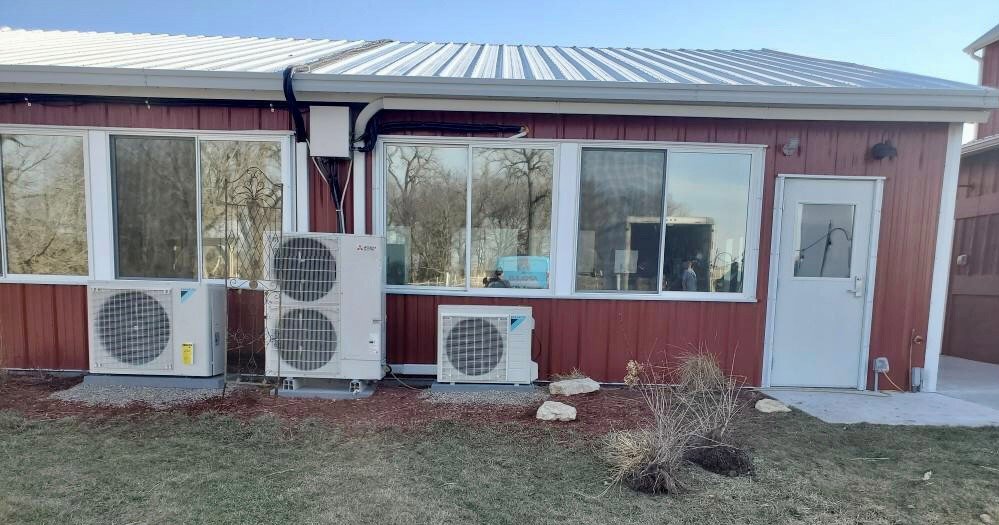 Multiple outdoor mini-split HVAC units installed on the side of a commercial building by Apollo Heating and Air in Bellevue, NE.