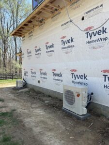 Two outdoor mini-split HVAC units installed next to a residential building by Commercial Service in Bloomington, IN.