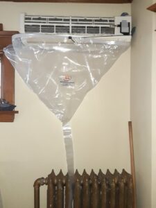 A mini-split indoor unit being professionally cleaned using a SpeedClean bag by Elements Heating & Cooling LLC in Minneapolis, MN.