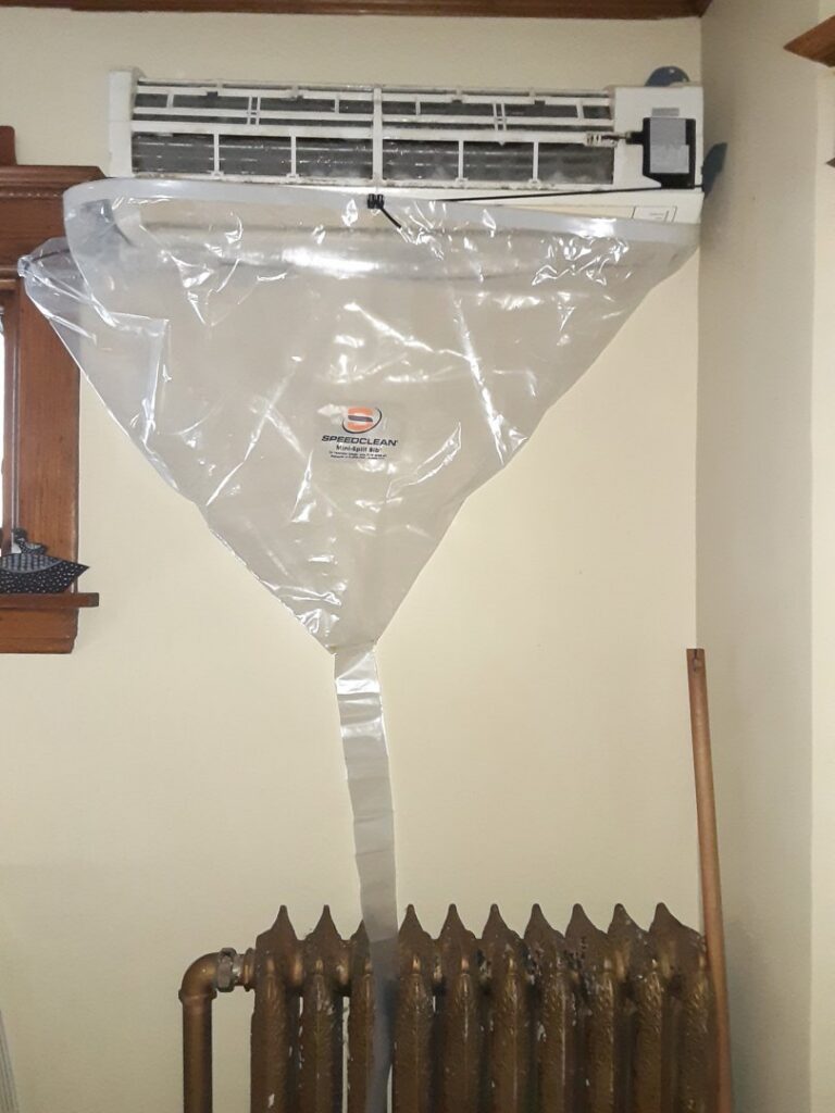 A mini-split indoor unit being professionally cleaned using a SpeedClean bag by Elements Heating & Cooling LLC in Minneapolis, MN.
