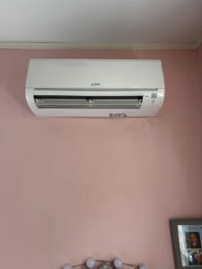 A white mini-split indoor air conditioning unit installed on a pink wall by Calloway & Sons A/C And Heating in New Orleans, LA.