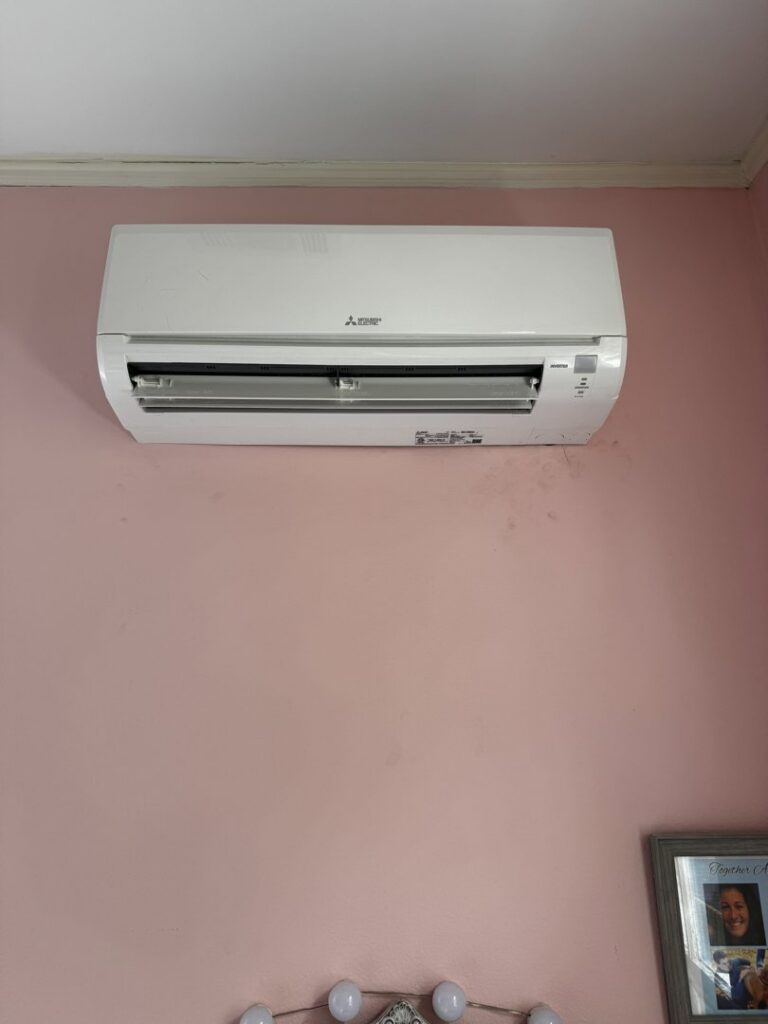 A white mini-split indoor air conditioning unit installed on a pink wall by Calloway & Sons A/C And Heating in New Orleans, LA.