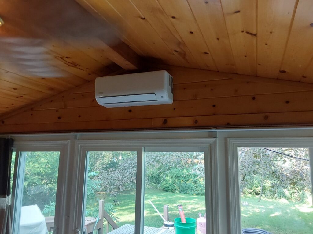 A mini-split indoor unit installed on a wooden wall in a sunroom by Nimmer Heating & Air Conditioning in Milwaukee, WI.