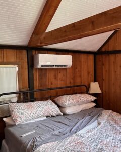 An indoor mini-split HVAC unit installed in a wood-paneled bedroom by Integrity Aire in St. Charles, MO.