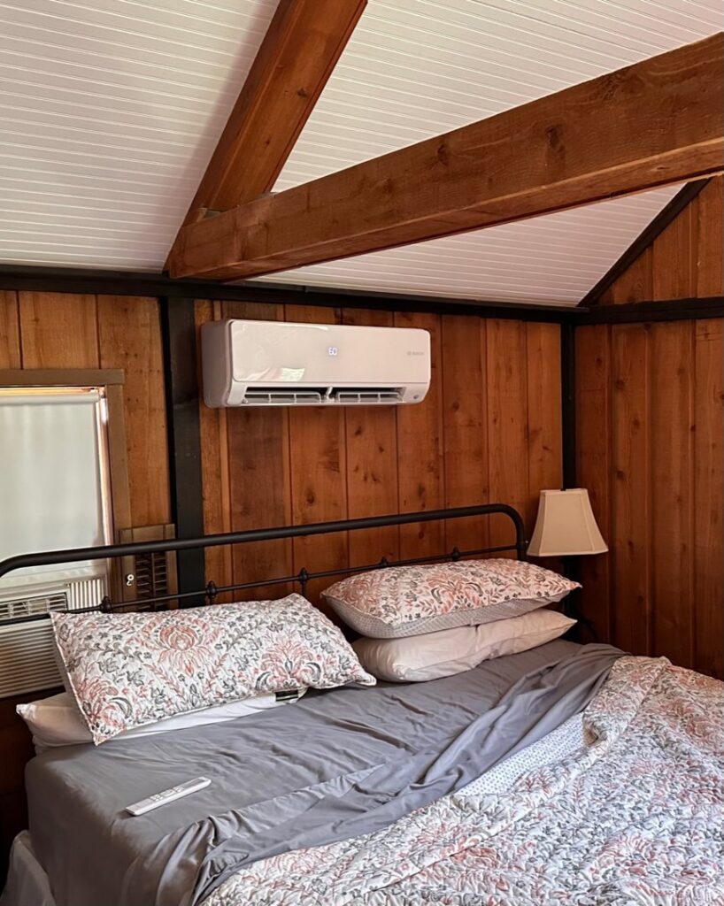 An indoor mini-split HVAC unit installed in a wood-paneled bedroom by Integrity Aire in St. Charles, MO.