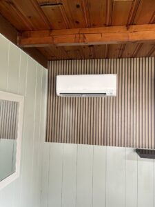 An indoor mini-split head unit installed on a decorative wood-paneled wall by Climate Diagnostics in Buffalo, NY.