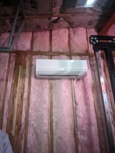 An indoor mini-split HVAC unit installed on an insulated wall, likely in a garage or workshop, by Bama Air Systems in Cullman, AL.