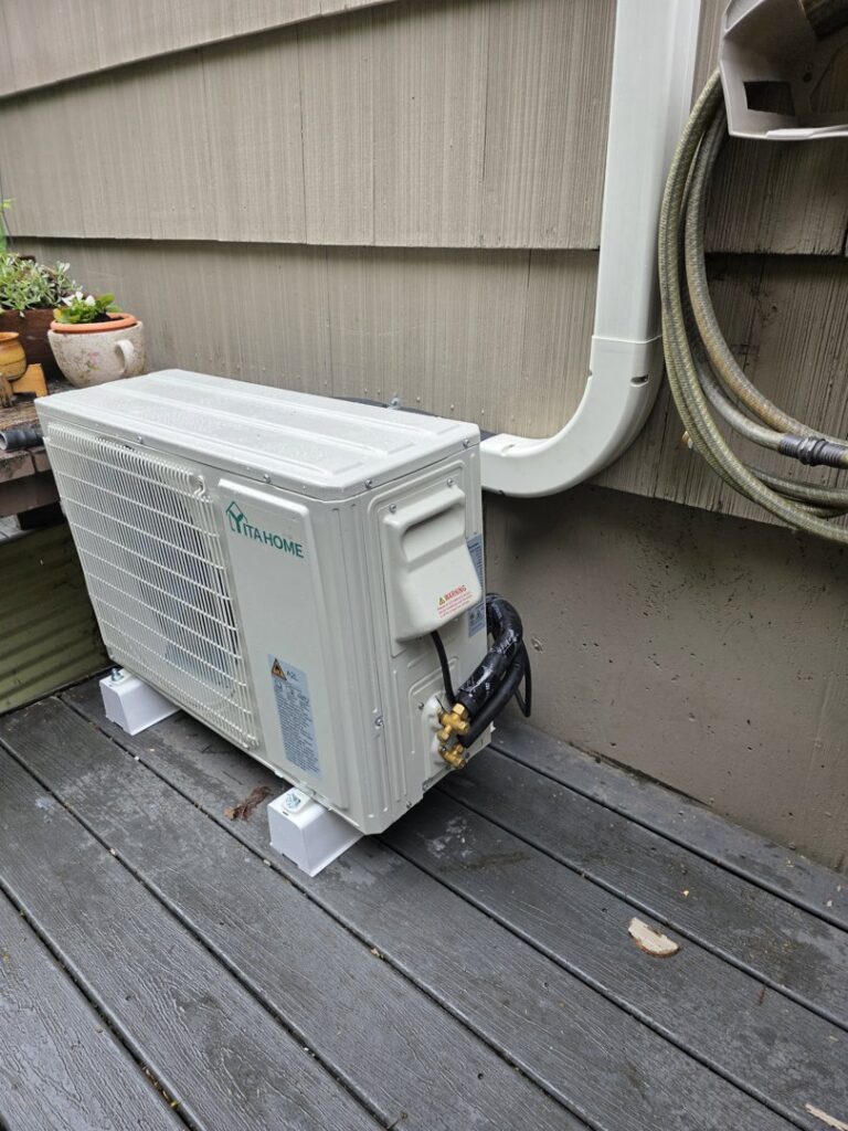 An outdoor mini-split condenser unit installed on a residential deck by 406 Heating & Cooling LLC in Missoula, MT.