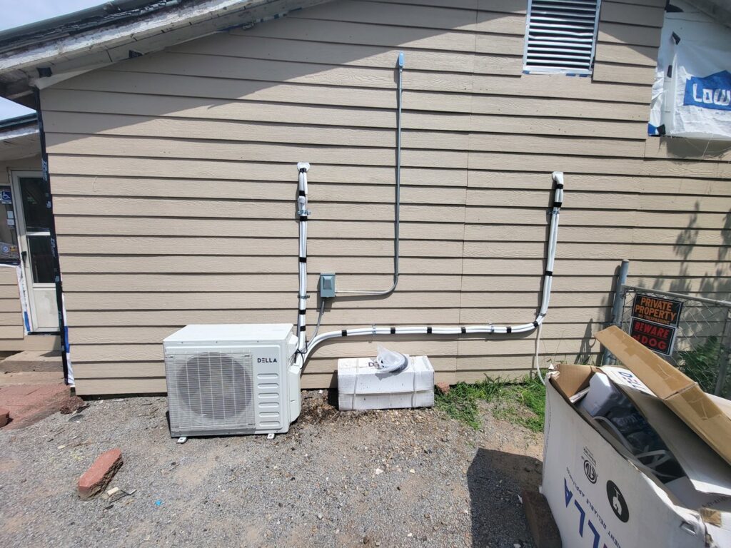Outdoor mini-split condenser unit installation by Chapman HVAC on the side of a building in Cleveland, OK.