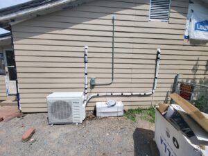 Outdoor mini-split condenser unit installation by Chapman HVAC on the side of a building in Cleveland, OK.