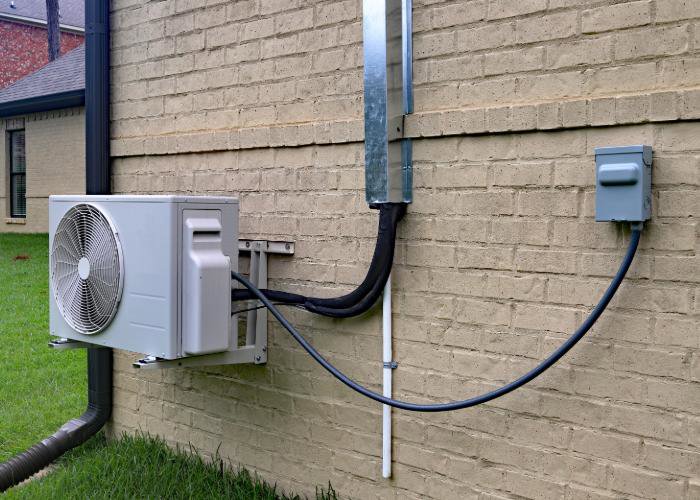 A mini-split outdoor unit installed on a wall by Greater Boston Heating & Air in Boston, MA.
