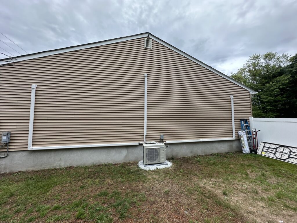 An outdoor mini-split unit and line sets installed on the side of a house by Green Mechanical LLC in Philadelphia, PA.