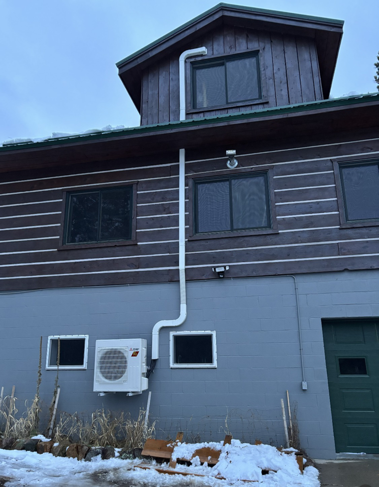 An outdoor mini-split HVAC unit installed on the side of a building by One Way Service Pros in Deadwood, SD.