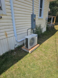 Side view of an outdoor mini-split condenser unit installation by Southern Heating & A/C LLC in Mobile, AL.