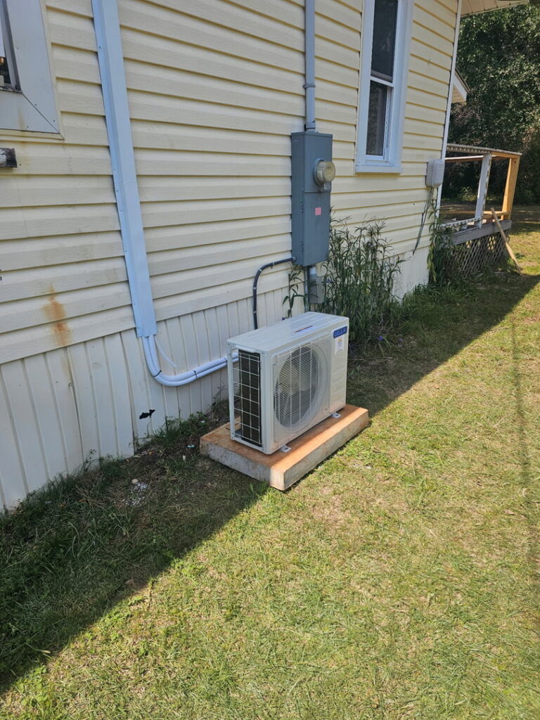 Side view of an outdoor mini-split condenser unit installation by Southern Heating & A/C LLC in Mobile, AL.