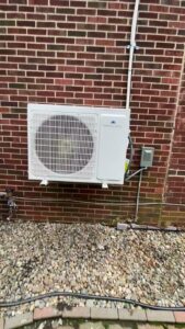 A newly installed mini-split outdoor unit on a brick wall by Total HVAC - Heating and Cooling in Nashville, TN.