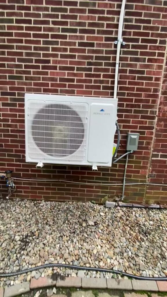 A newly installed mini-split outdoor unit on a brick wall by Total HVAC - Heating and Cooling in Nashville, TN.