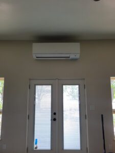 A mini-split air conditioning unit installed above double doors by Pacheco Air Conditioning and Heating LLC in Albuquerque, NM.