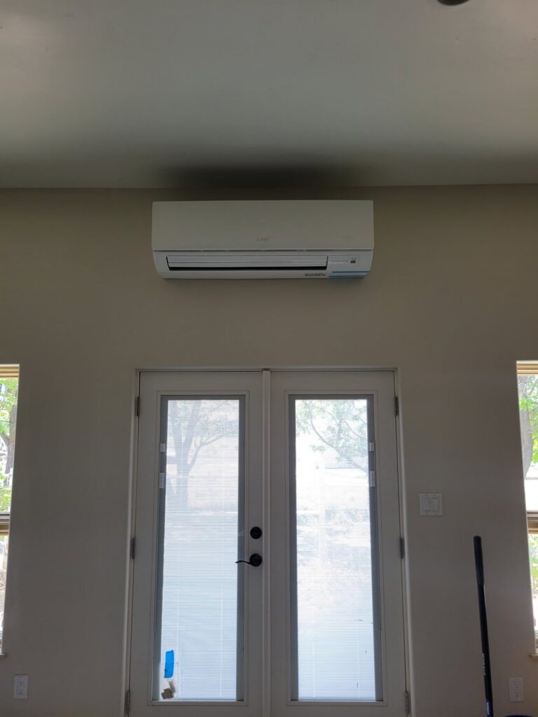 A mini-split air conditioning unit installed above double doors by Pacheco Air Conditioning and Heating LLC in Albuquerque, NM.