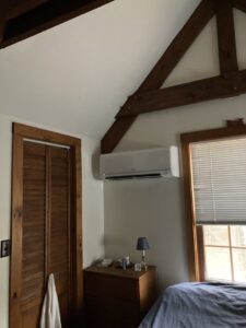 An indoor mini-split unit installed on a wall beneath exposed wooden beams, demonstrating an HVAC job by A&D Ductless LLC in Lunenburg, MA.