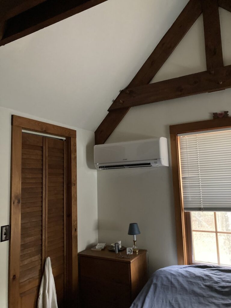An indoor mini-split unit installed on a wall beneath exposed wooden beams, demonstrating an HVAC job by A&D Ductless LLC in Lunenburg, MA.