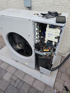 An open outdoor mini-split unit showing internal components during service by Quantum Cooling & Heating in Mesa, AZ.