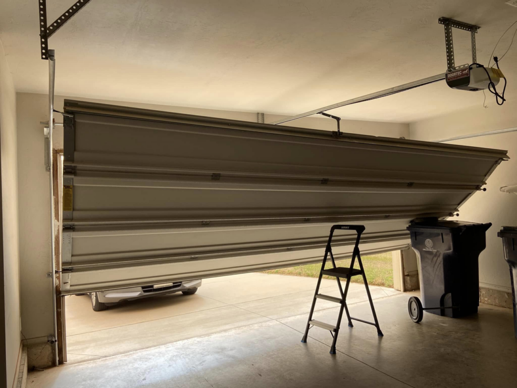 A misaligned garage door with visible opener mechanism, indicating a repair job by Unhinged Garage Doors LLC in Oklahoma City, OK.