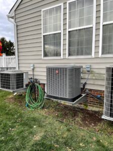 A Mitsubishi Electric mini-split outdoor condenser unit installed on a brick wall by Trusted HVAC in Martinsburg, WV