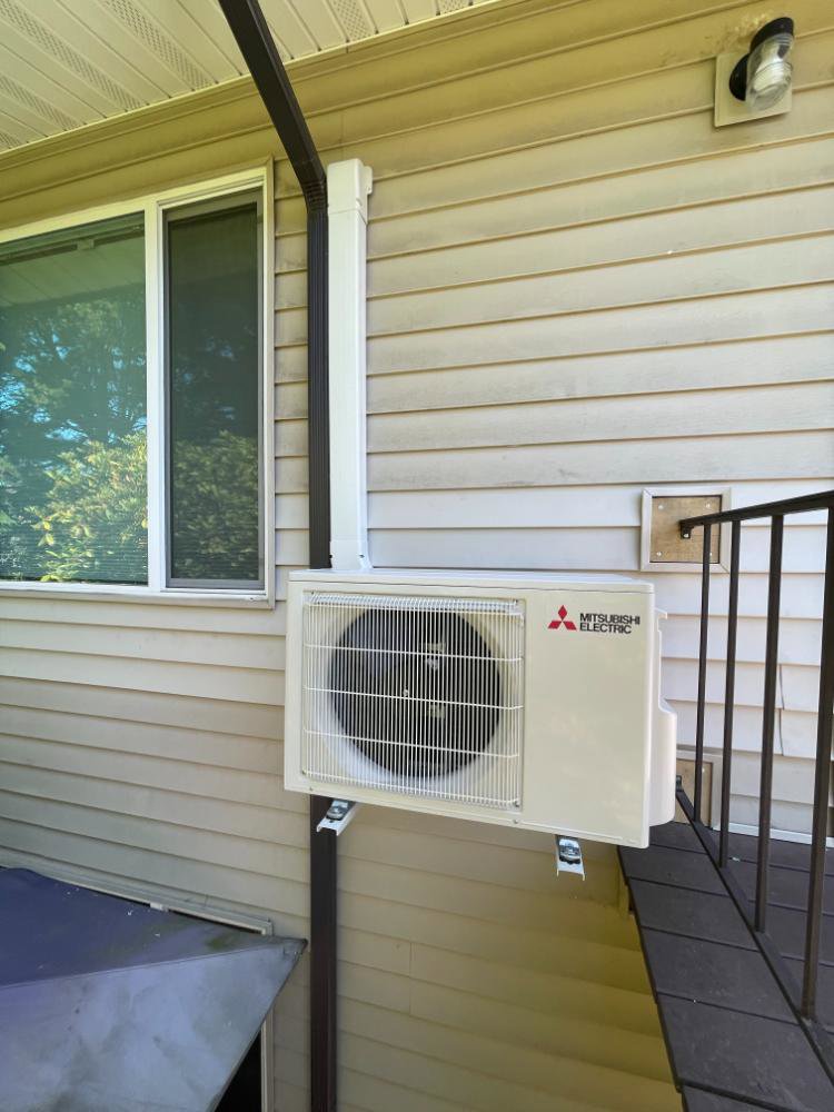 A Mitsubishi Electric mini-split outdoor unit installed on a building wall by Smart HVAC LLC in Vancouver, WA.