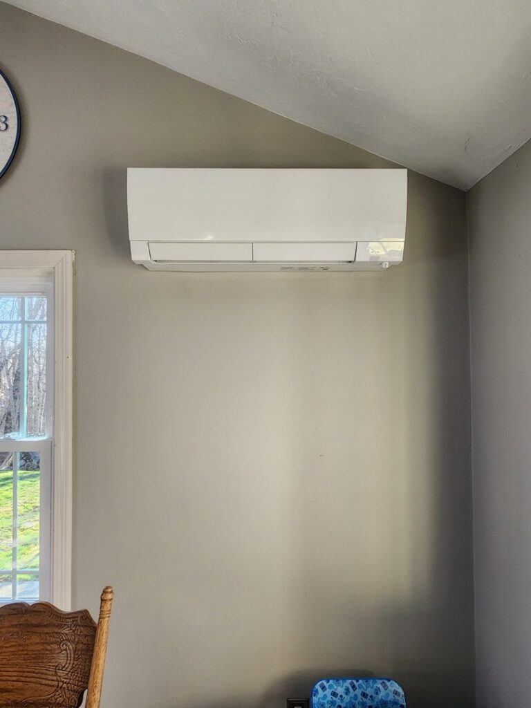 A white Mitsubishi mini-split indoor unit installed on a wall by C & C Temp Control in Worcester, MA.
