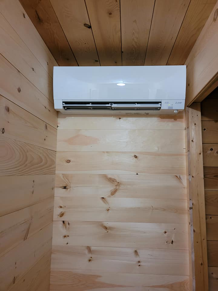 An indoor Mitsubishi mini-split head unit professionally installed on a wooden wall by Maine Thermal Energy Services in Ellsworth, ME