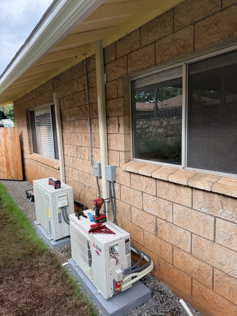 Installation of two Mitsubishi Electric mini-split outdoor units next to a brick house by Air Masters, Inc. in Port Orchard, WA.