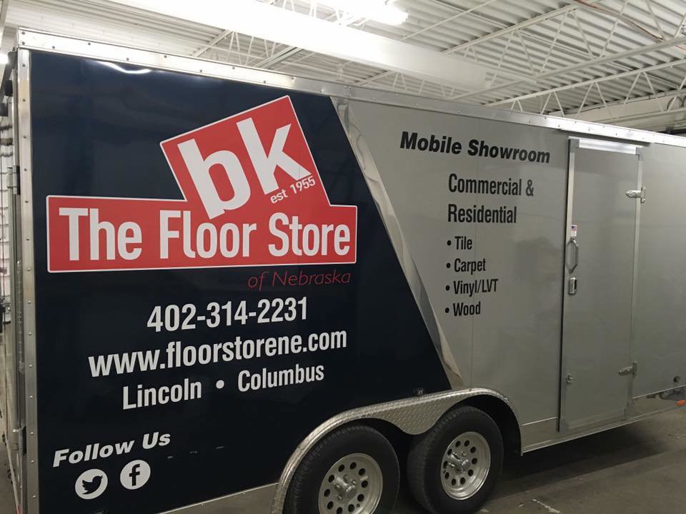 A mobile showroom trailer advertising carpet installation and sales for BK The Floor Store of Nebraska in Columbus, NE.