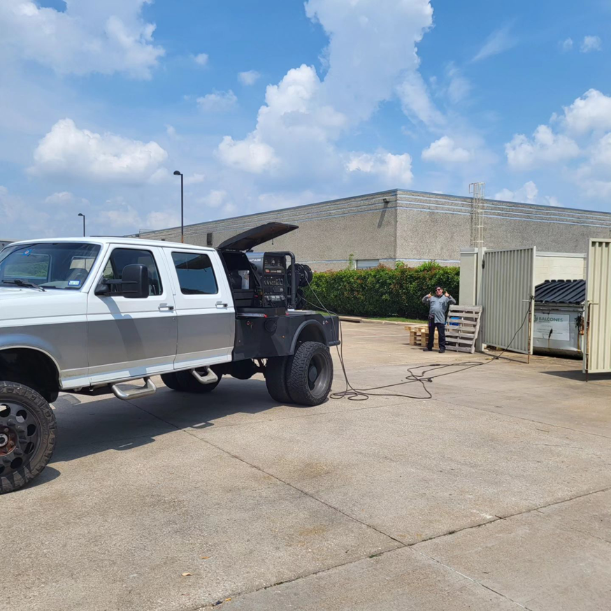 A Dallas Mobile Welder, LLC. truck with welding equipment at a commercial gate installation site in Dallas, TX.