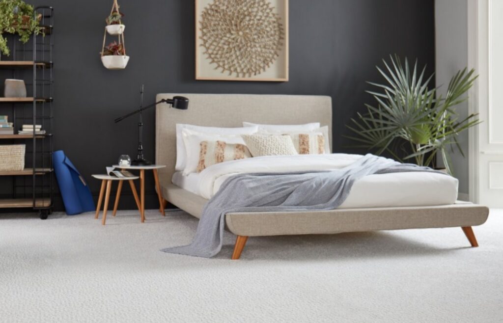 A modern bedroom featuring a soft, light-colored carpet installation by Wall To Wall Carpet One Floor & Home in Eau Claire, WI