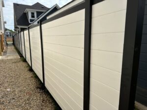 A modern black and white horizontal privacy fence installed along a narrow pathway by Render Fences in Fishers, IN.