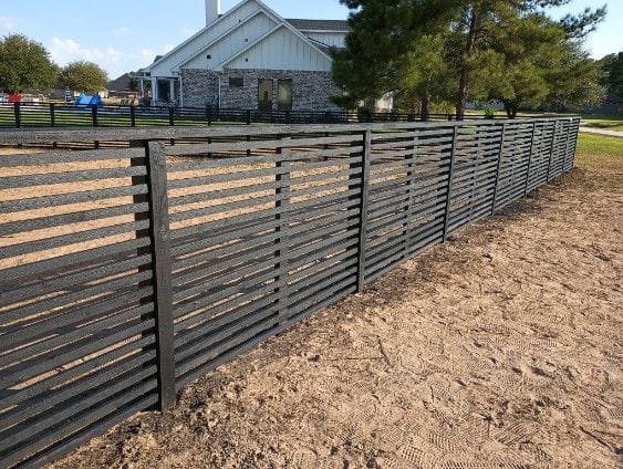 A modern black horizontal slat fence design, offering a sleek and contemporary look from Fence Builders of Houston, TX.
