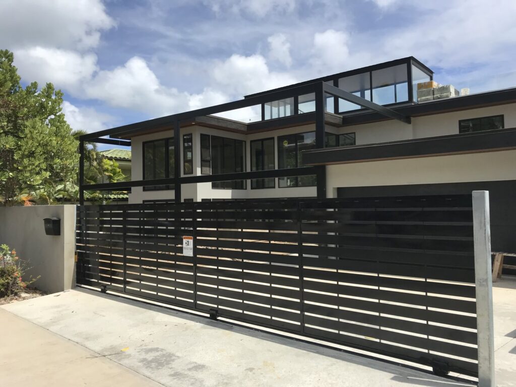 A modern black horizontal slat sliding gate installed for a residential property by A&D Services in Kapolei, HI.
